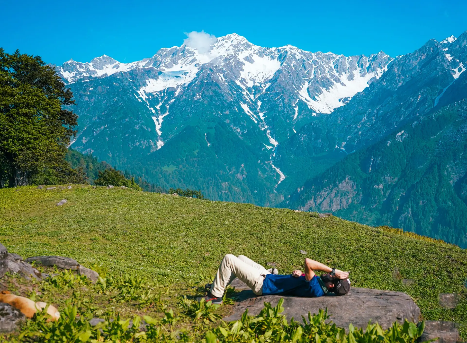 A lonely male lying down and sunbathing on a meadow with mountains in BG