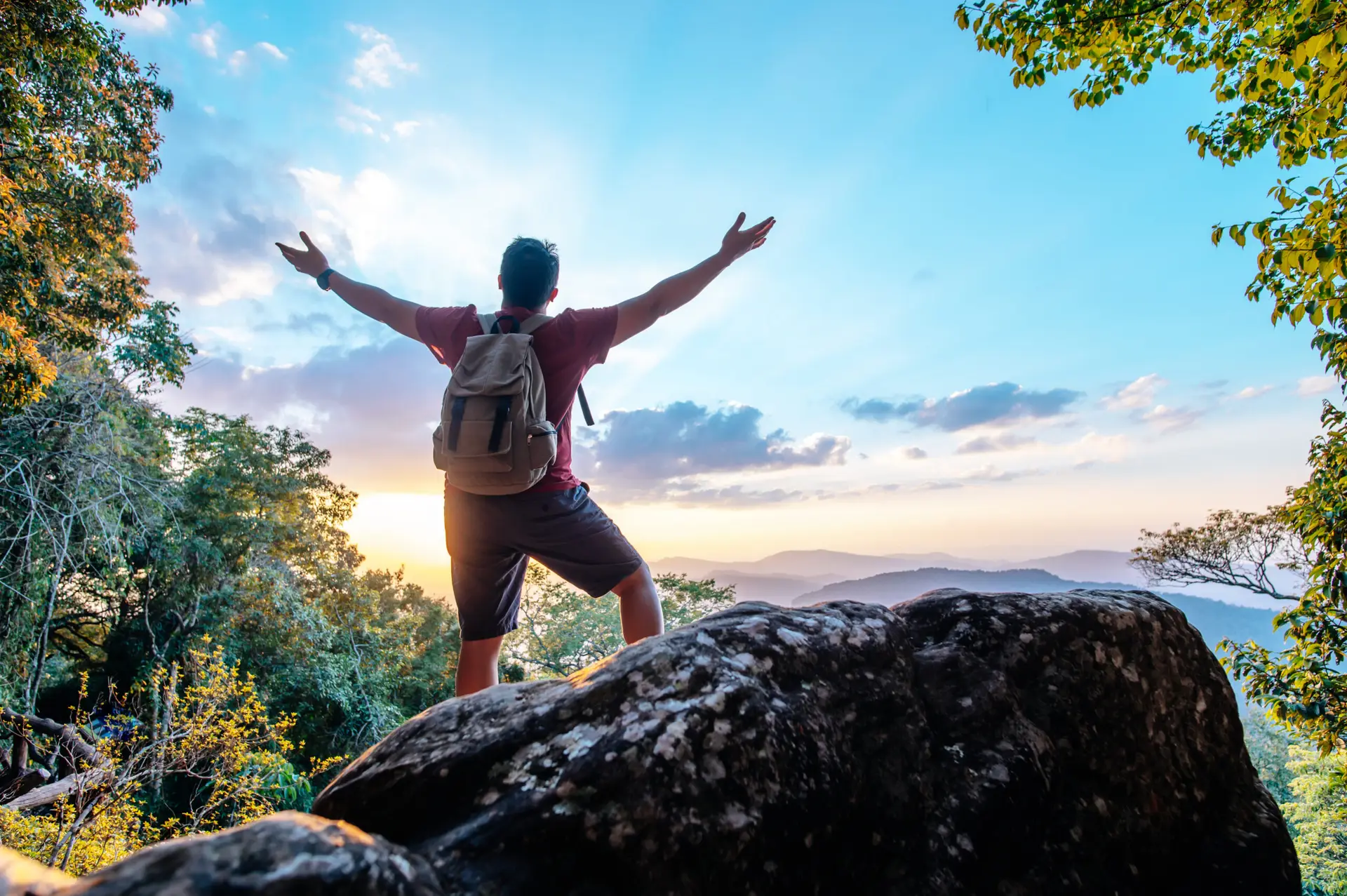 Rear view back of Young asian hiking man standing and rise-up hands with happy on peak of rocky mountain, copy space
